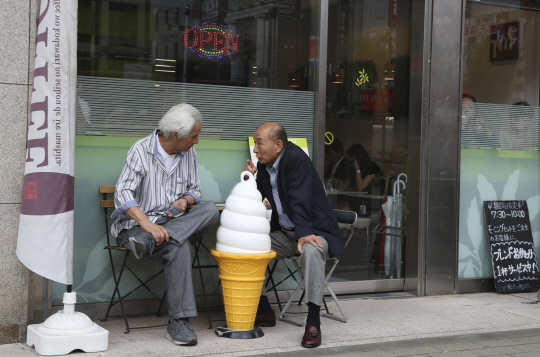 일본 도쿄 시내의 한 커피숍 앞에서 두 노인이 이야기를 나누고 있다./도쿄=AP연합뉴스