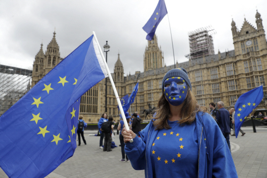 영국의 EU 잔류를 희망하는 한 여성이 5일(현지시간) 런던 의회의사당 앞에서 EU 국기 색으로 얼굴과 옷을 통일하고 EU깃발을 든 채 시위를 벌이고 있다./런던=AP연합뉴스