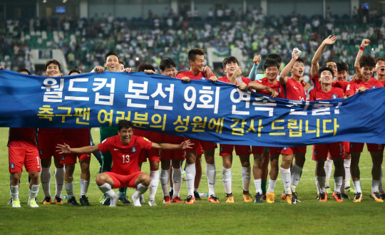 한국 축구대표팀 선수들이 6일 우즈베키스탄 원정 0대0 무승부로 러시아월드컵 본선 진출을 확정한 뒤 기념 현수막을 펼쳐 들고 환호하고 있다. /연합뉴스