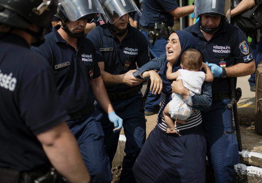 헝가리 부다페스트에서 경찰에 체포되고 있는 한 이민가정 /AFP연합뉴스