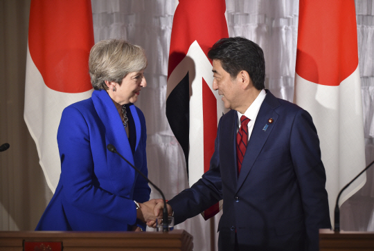 테리사 메이(왼쪽) 영국 총리와 아베 신조 일본 총리가 지난달 31일 일본 도쿄에서 열린 정상회담 직후 손을 맞잡고 있다./도쿄=AP연합뉴스