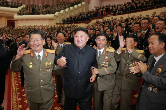 김정은 북한 노동당 위원장이 수소탄 시험성공 기념 축하연에 참석해 발사 관계자들의 환호를 받으며 중앙무대로 이동하고 있다. 조선중앙통신은 이 같은 내용을 10일 보도했다. /연합뉴스