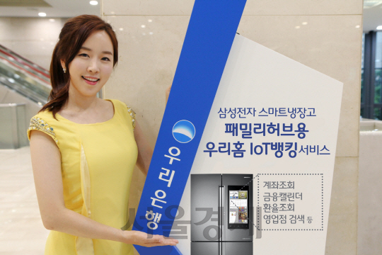 우리은행 모델이 12일 서비스를 실시한 삼성전자스마트냉장고 패밀리허브용 우리홈 IoT 뱅킹 서비스를 소개하고 있다. /사진제공=우리은행