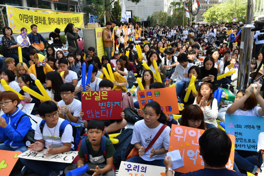 13일 서울 중학동 옛 일본대사관 앞에서 열린 1,300번째 일본군 성노예 문제 해결을 위한 정기 수요집회에 참여한 시민들이 일본의 사과와 진상규명을 요구하는 구호를 외치고 있다.           /연합뉴스