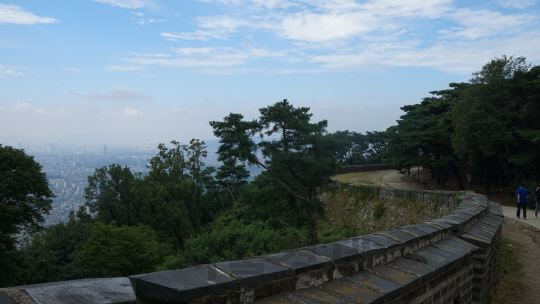 굽이치는 남한산성의 성곽 위로 푸른 하늘이 넓게 펼쳐져 있다.