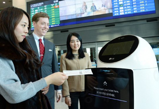 인천국제공항 이용객이 LG전자 안내로봇에게 출국 게이트를 묻고 있다. LG전자는 현재 인천국제공항에서 안내로봇 시범 서비스를 진행 중이다. /사진제공=LG CNS
