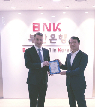 김성화(오른쪽) BNK부산은행 자금시장본부장 직무대행이  14일 아르논 골드스타인(Arnon Goldstein) 뉴욕멜론은행 아시아태평양본부 대표로부터 외화송금자동처리 최우수기관상(STP Award)을 받고 있다. 부산은행은 4년 연속 STP Award를 수상했다./사진제공=부산은행