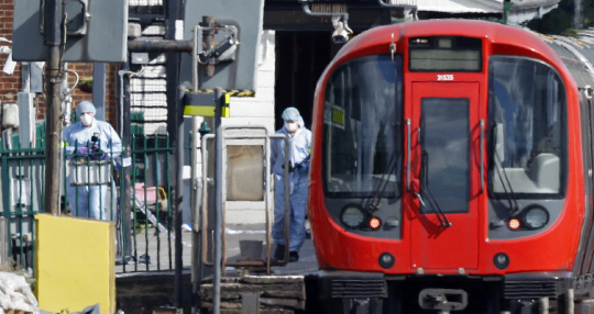 15일(현지시간) 영국 런던 남서부 파슨스 그린 지하철역에서 발생한 사제 폭탄 테러의 원인을 조사하기 위해 검시관들이 열차 주변을 수색하고 있다. /런던=AFP연합뉴스