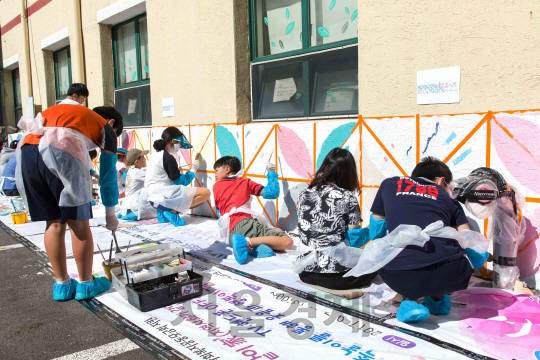 지난 16일 한국투자증권 참벗나눔 봉사단원과 임직원 자녀들이 풍납종합사회복지관을 찾아 벽화를 그리고 있다. /사진제공-한국투자증권
