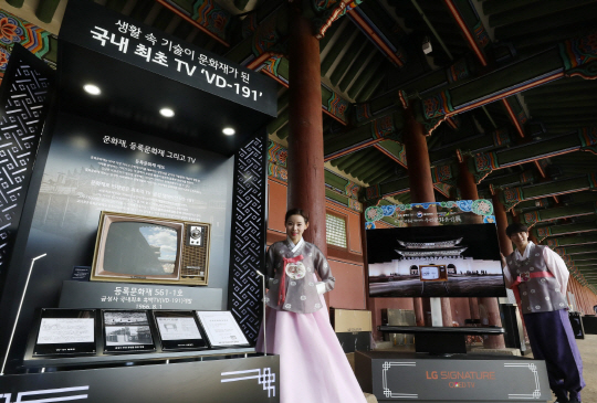 LG전자 모델들이 서울 경복궁에 설치된 ‘LG 시그니처 올레드 TV W(오른쪽)’와 등록문화재로 지정된 우리나라 최초의 TV ‘VD-191(왼쪽)’을 선보이고 있다. LG전자는 문화재청과 함께 경복궁에서 유무형 문화유산을 소개하는 ‘최고의 작품을 만나다. 우리 문화유산전’을 진행하고 있다. 다음달 9일까지 열리는 이번 전시회에서 LG전자는 올레드 TV 17대를 경복궁에 설치하고 우리 문화유산을 영상으로 소개한다./사진제공=LG전자