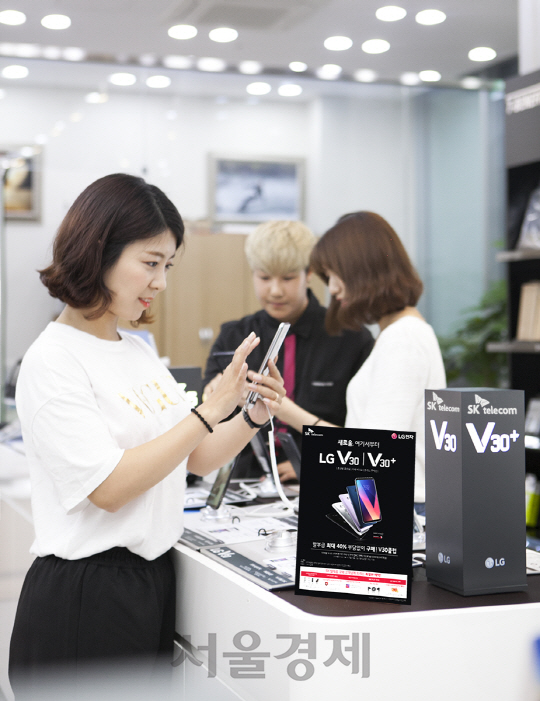 SK텔레콤 모델이 SK텔레콤 대리점에서 LG전자의 플래그십 스마트폰 ‘V30’를 살펴보고 있다. /사진제공=SK텔레콤