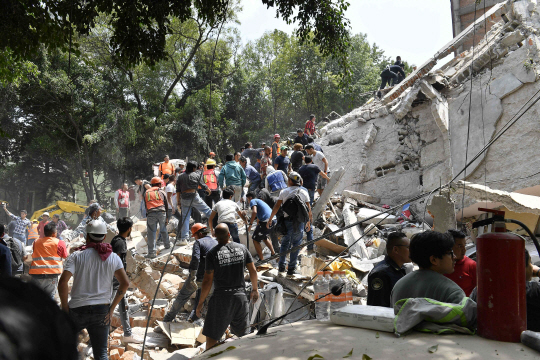 19일(현지시간) 멕시코 수도 멕시코시티에서 구조대가 붕괴된 건물에서 생존자를 찾고 있다.  /멕시코시티=AFP연합뉴스