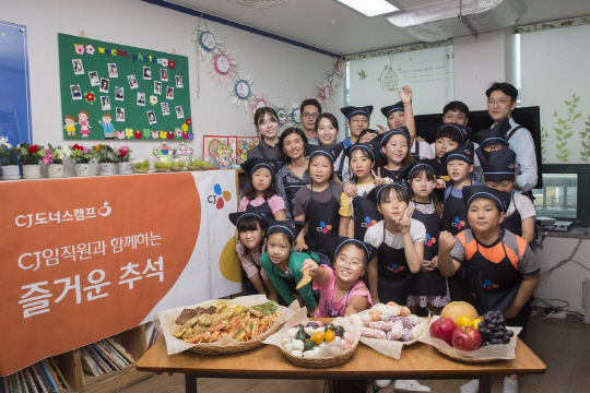 CJ그룹 임직원들이 지난 22일 서울 강서구의 한 지역아동센터에서 명절 음식을 만드는 봉사활동을 한 후 어린이들과 기념촬영을 하고 있다. CJ그룹은 CJ도너스캠프가 후원하는 전국 156개 지역아동센터에서 어린이들을 위한 명절 음식 만들기 요리 강습을 진행했다. /사진제공=CJ그룹