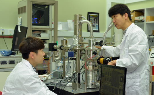 KRISS 조복래(오른쪽)박사가 연구진과 함께 광전자 융합현미경으로 시료를 관찰하고 있다. 사진제공=KRISS