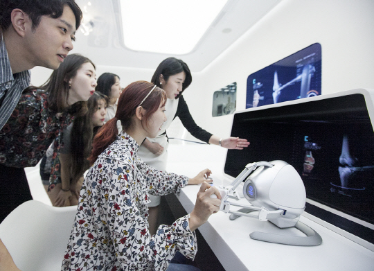 SK텔레콤이 새롭게 단장한 ICT 체험관 ‘티움’에서 방문객들이 가상현실(VR) 기반의 인공 뼈 수술 체험을 하고 있다. /사진제공=SK텔레콤