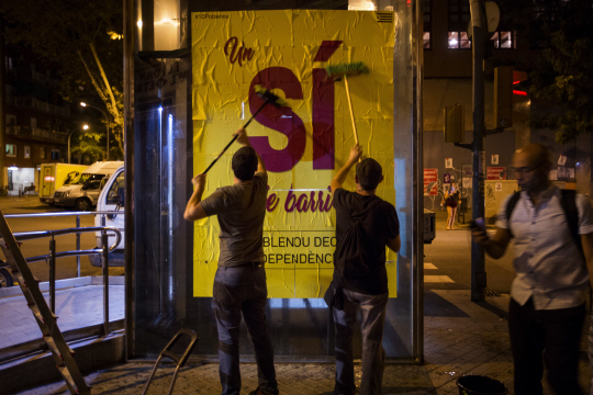 28일 스페인 바르셀로나에서 시민들이 독립 투표 참여를 독려하는 포스터를 붙이고 있다. /바르셀로나=AP연합뉴스