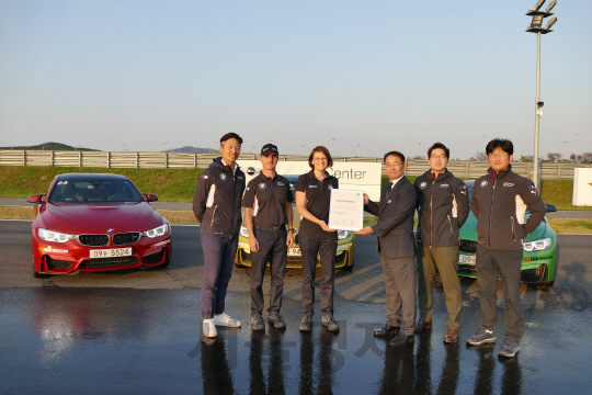 장성택(오른쪽 셋째)BMW 드라이빙센터 상무가 28일 BMW 미니 드라이빙 익스피리언스 담당자들로 부터 인천 영종도 BMW 드라이빙센터의 레벨1 인증서를 전달받고 웃고 있다./사진제공=BMW 코리아