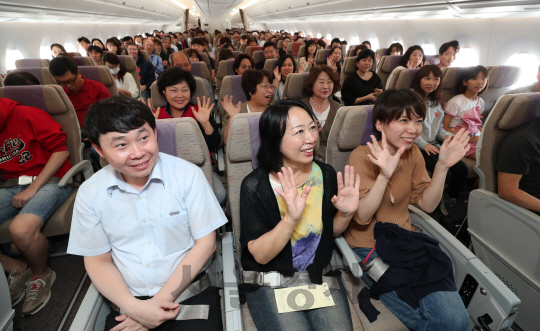 추석연휴를 앞두고 29일 오후 탑승률 100%를 기록하며 인천공항을 출발해 일본 오사카로 향하는 아시아나 OZ114편 항공기 안에서 승객들이 손을 흔들며 즐거워하고 있다. OZ114편은 27일 신규 도입한 A350 3호기의 첫 운항편이며 29일부터 10월 2일 추석 연휴 초반 인천공항을 출발하는 아시아나항공의 평균 예약율은 95%에 달한다./영종도=이호재기자