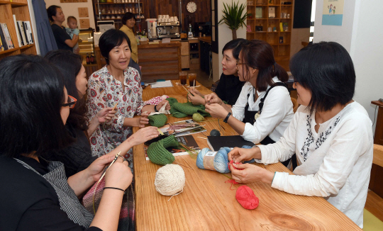 지난 26일 서울 은평구 진관동 상림마을에 위치한 마을생활공간 ‘물푸레북카페’에서 지역주민들이 한자리에 모여 뜨개질을 하면서 대화를 나누고 있다./이호재기자.