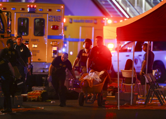 1일(현지시간) 밤 미국 네바다 주 라스베이거스 만델레이 베이 호텔에서 구조대원이 손수레로 부상자를 옮기고 있다./라스베이가스=AP연합뉴스