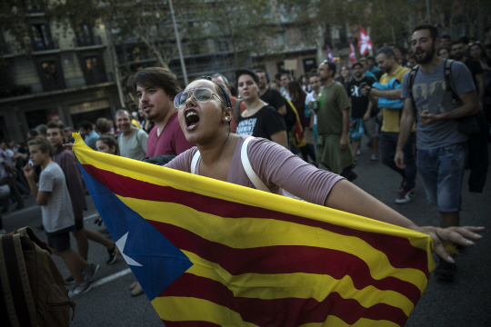 3일(현지시간) 스페인 바르셀로나 도심에서 분리독립을 요구하는 카탈루냐 지역 주민들의 대규모 시위가 벌어진 가운데, 한 여성이 카탈루냐 독립기인 ‘에스텔라다’를 펼쳐들고 구호를 외치고 있다./AP연합뉴스
