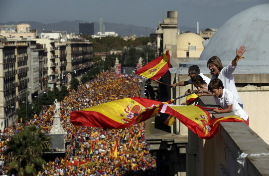 스페인 카탈루냐 지방 최대도시 바르셀로나에서 8일(현지시간) 카탈루냐 분리독립에 반대하는 시민들이 거리 행진을 하는 가운데 지붕 위에서 사람들이 스페인 국기를 흔들고 있다./AP연합뉴스