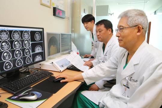 권도훈(오른쪽) 서울아산병원 교수 등 방사선수술센터 의료진이 감마나이프 수술 환자의 뇌 영상을 보며 감마나이프 수술을 하고 있다. /사진제공=서울아산병원