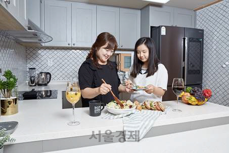 ‘씨랩키친’을 시공한 주부 오현자 씨가 딸과 함께 주방에서 요리를 하고 있다. /사진제공=까사미아