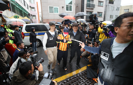 지난 11일 오전 중학생 딸 친구 살해·시신 유기 사건의 피의자 ‘어금니 아빠’ 이영학씨가 현장 검증을 하기 위해 이씨가 거주했던 서울 중랑구 망우동의 자택으로 들어서는 가운데 주민들이 분노하며 모여들고 있다. /연합뉴스