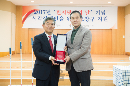 김성채(왼쪽)금호석유화학 사장이 백남식 한국시각장애인복지관장에게 ‘흰지팡이의 날’을 맞아 시각장애인용 흰지팡이 제작 후원금을 전달하고 있다. /사진제공=금호석유화학.