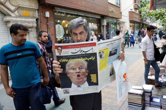한 이란인 남성이 14일(현지시간) 이란 수도 테헤란에서 ‘미친 트럼프 그리고 논리적인 이란 핵협정’이라는 제목으로 1면을 장식한 일간지를 읽고 있다.  /테헤란=EPA연합뉴스