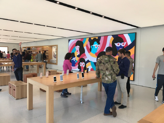 실리콘밸리 애플 본사 입구에 자리한 애플 스토어에서 방문객들이 아이폰을 이용해 보고 있다. /새너제이=양철민기자