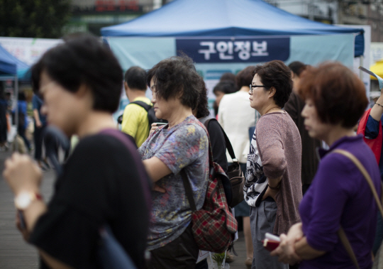 지난달 19일 서울 성북천 분수마루에서 열린 취업박람회에서 참석자들이 일자리 정보를 살펴보고 있다. /연합뉴스