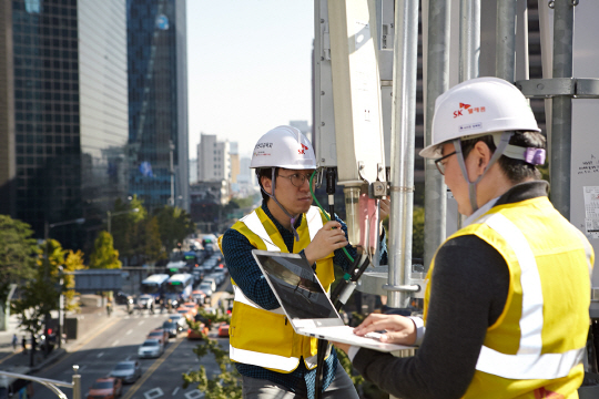 SK텔레콤 5G연구원들이 서울 명동의 건물 옥상에 설치된 5G 기지국에서 LTE-5G 장비  및 주파수 연동 결과를 측정하고 있다. /사진제공=SK텔레콤