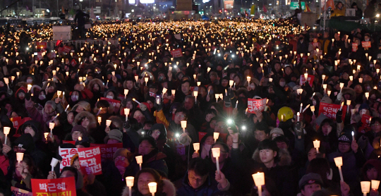 지난해 12월10일 서울 광화문 광장에서 열린 ‘제7차 민중총궐기’에 참가한 시민들이 촛불을 들고 있다. 연인원 1,700만명이 참석한 촛불집회는 총 23차례 열렸다.  /서울경제DB