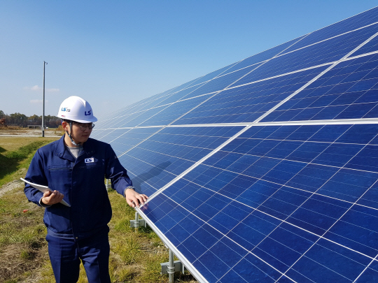 LS산전이 한국전력과 함께 참여한 28MW급 일본 치토세 태양광 발전소에서 LS산전 관계자가 태양광 모듈을 점검하고 있다. /사진제공=LS산전