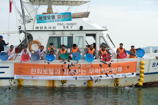 한화토탈은 지난 26일 회사 임직원과 지역단체 및 주민 200여명이 참석한 가운데 충남 대산공장 인근 앞바다에서 ‘치어 방류 행사’를 진행했다. 행사에 참가한 주민과 한화토탈 임직원들이 우럭 치어들을 바다에 방류하고 있다. /사진제공=한화토탈