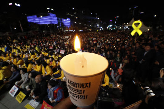 28일 저녁 서울 종로구 광화문 광장에서 박근혜정권퇴진 비상국민행동 기록기념위원회 주최로 열린 촛불 1주년 기념대회 ‘촛불은 계속된다’에서 참석자들이 촛불을 들어 광장을 밝히고 있다. / 연합뉴스