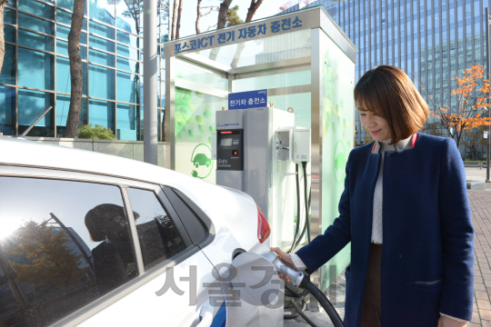 한 시민이 포스코ICT의 전기차 충전기를 이용해 전기배터리를 충전하고 있다./서울경제DB