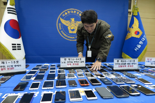 서울 동대문경찰서 경찰관이 2일 도난·분실 신고된 휴대폰을 썼다가 적발돼 압수한 휴대폰을 정리하고 있다.  /연합뉴스