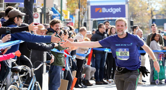 5일(현지시간) 열린 뉴욕마라톤 대회에 참가한 한 선수가 보도의 시민들에 응원을 받으며 달리기를 이어가고 있다./사진제공 = 뉴욕마라톤