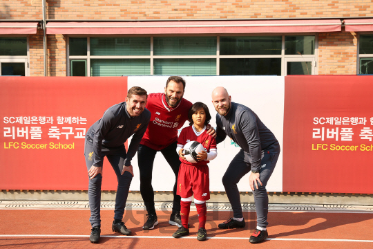 패트릭 베르게르(왼쪽 두번째) 리버풀FC 레전드 선수와 인터내셔널 아카데미 코치진이 4일 서울 서초구 ‘덜위지칼리지 서울영국학교’에서 SC제일은행 주최로 열린 ‘리버풀 축구교실’ 참가 어린이와 기념촬영을 하고 있다./사진제공=SC제일은행