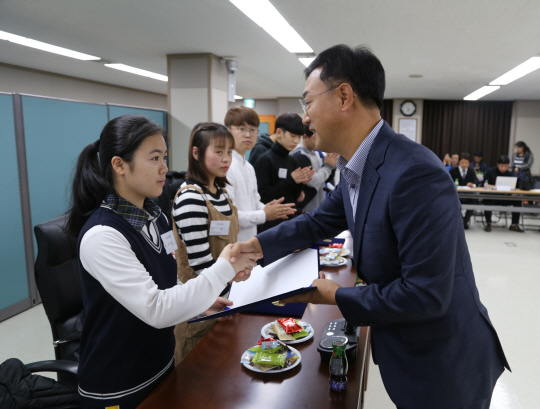 주복원(오른쪽) 한전산업개발 사장이 지난 7일 북한이탈주민 장학생 대표에게 장학증서를 전달한 뒤 악수를 하고 있다. /사진제공=중견련