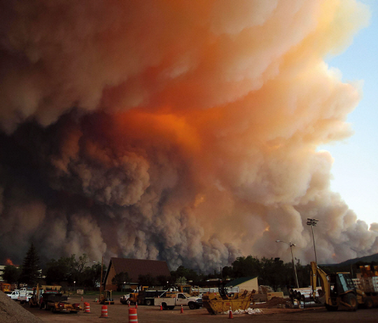 하늘로 솟구쳐 오르는 불길 : 6월 26일, 화염과 연기가 로스 알라모스 상공을 뒤덮고 있다. 화재 전문가들은 야간의 찬 공기가 화재를 약화시킬 것으로 예상했으나, 자정 이후 화재는 더욱 심해졌다.