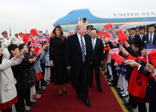8일 중국 베이징의 서우두 국제공항에 도착한 도널드 트럼프 대통령이 멜라니아 트럼프 영부인과 중국 측의 환대를 받으며 걸어가고 있다. /베이징=신화연합뉴스