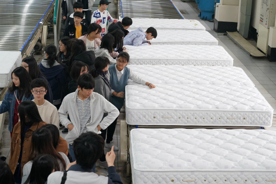 공장견학 프로그램에 참가한 학생들이 침대가 만들어지는 과정을 보며 이야기를 나누고 있다. /사진제공=에이스침대