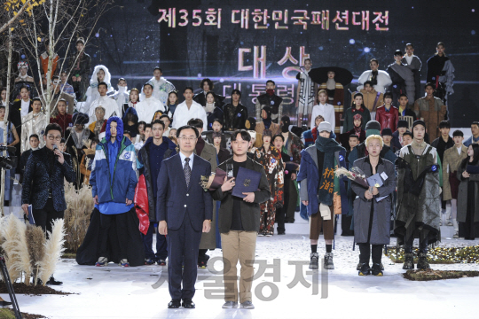 8일 SETEC에서 열린 35회 대한민국패션대전에서 문승욱 산업자원부 산업기반실장이 대상을 수상한 장시범 디자이너와 함께 기념촬영을 하고 있다./사진제공=한국패션협회