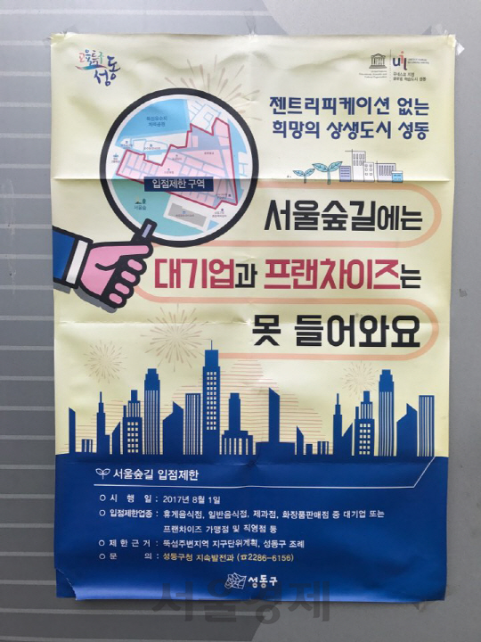 서울 성수동 서울숲길 구역에 프랜차이즈 입점을 제한한다는 내용의 포스터가 부착돼 있다./이지윤기자