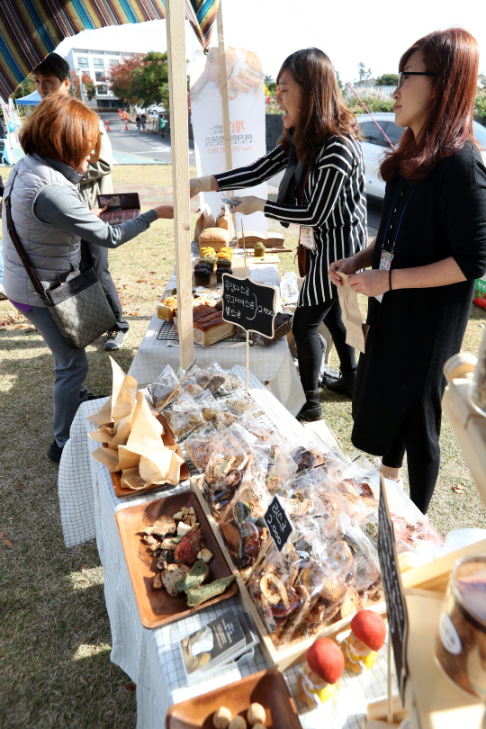 12일 제주시 제주관광대에서 열린 ‘제1회 비건 페스티벌 제주’ 참가자들이 채식주의자를 위해 우유, 버터, 계란 등을 쓰지 않은 비건(Vegan) 빵을 사고 있다. /연합뉴스