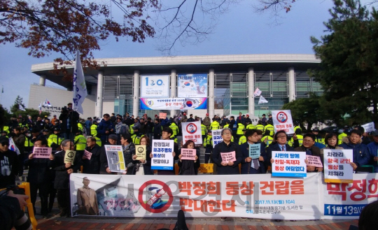 박정희 전 대통령 동상 기증식이 열린 13일 오전 10시 시민단체 관계자와 마포구민 100여명이 서울 마포구 박정희대통령 기념 도서관 앞에 모여 동상 건립을 반대한다는 구호를 외치고 있다./신다은 기자